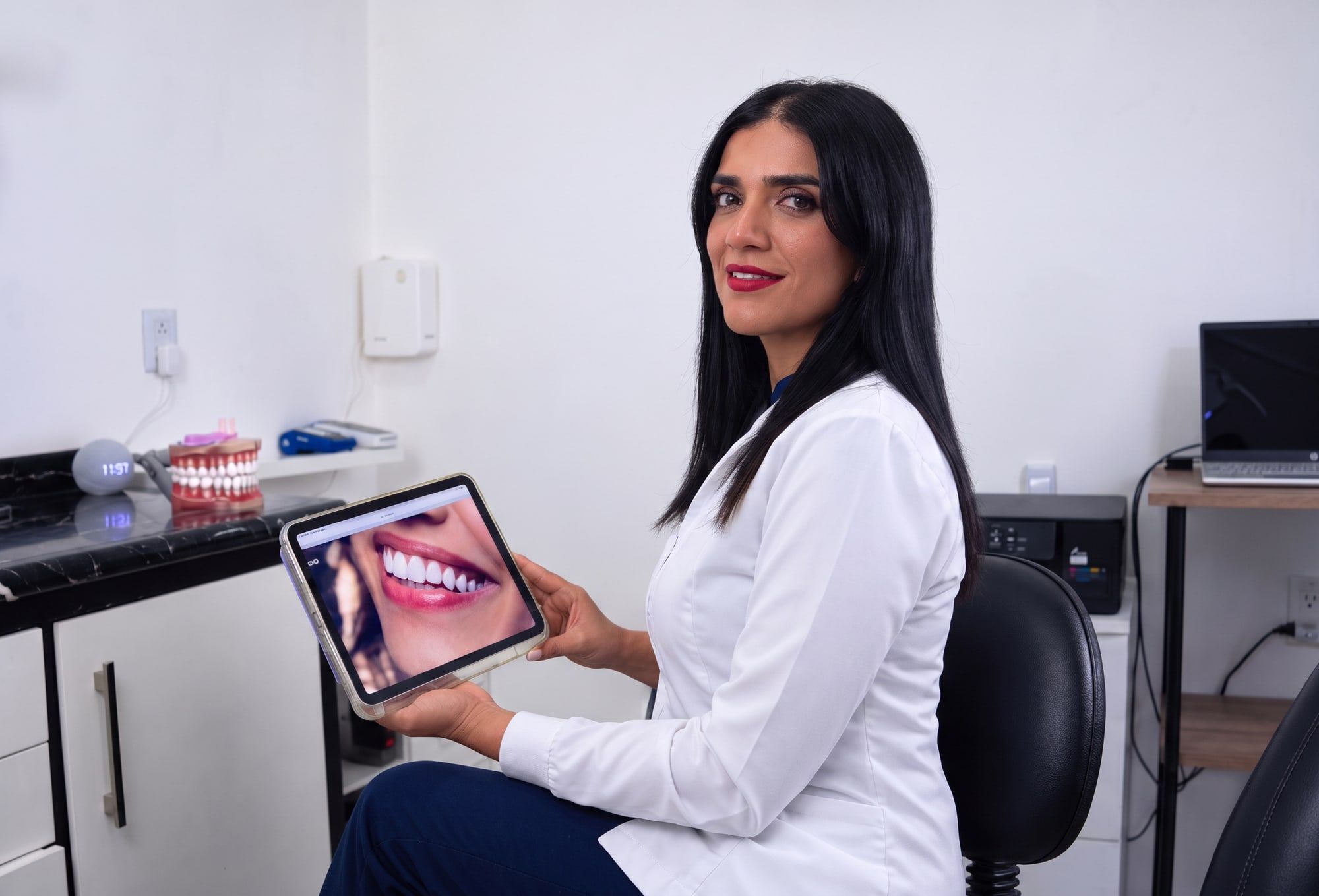 La doctora muestra en una tableta la vista previa de una sonrisa